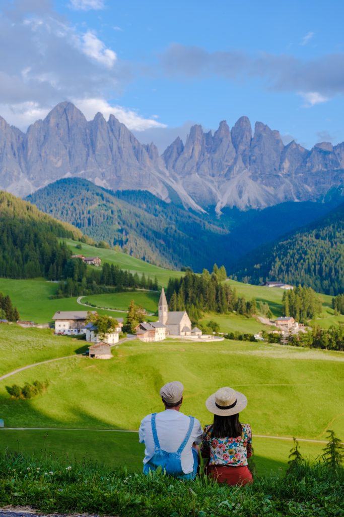 Couple At St. Magdalena Geisler Or Odle Dolomites Mountain Peaks. Val Di Funes Valley In Italy